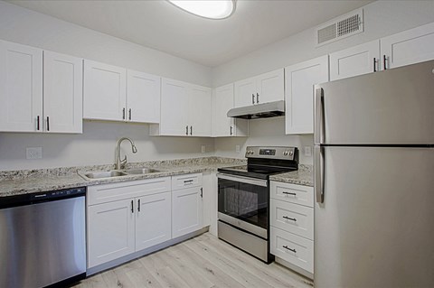 a kitchen with white cabinets and stainless steel appliances